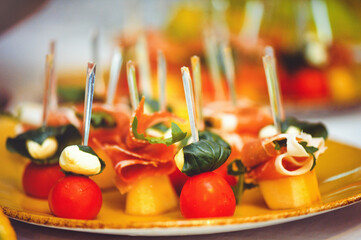 buffet at the reception. Glasses of wine and champagne. Assortment of canapes on a wooden board....