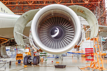 Industrial conceptual theme view. Repair and maintenance of aircraft engine with open hoods on the...