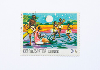 Guinea Republic Postage Stamp. circa 1968. 30 F. Legend of the moon and stars. African kids dancing at the night.