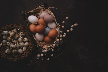 Vintage background with easter eggs in basket on dark background. Easter background with eggs and spring flowers. Top view with copy space.