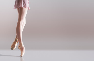 Ballerina's feet in pointe shoes standing isolated on white background