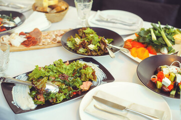 festive table with dishes, salads, meat dishes and side dishes