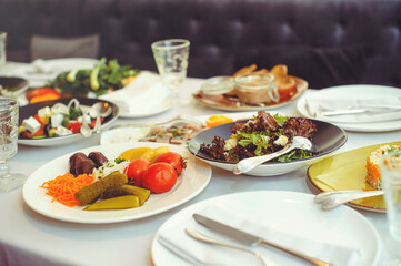 festive table with dishes, salads, meat dishes and side dishes