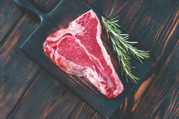 Raw T-bone steak with fresh rosemary