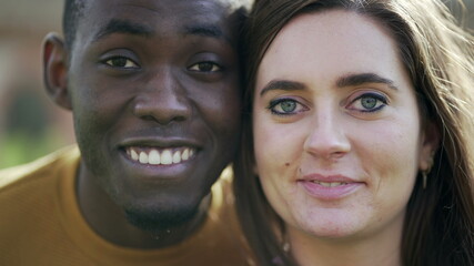 African man and white girl opening eyes together. Interracial couple looking at camera