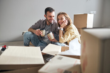 Spouses having a coffee break during unpacking things