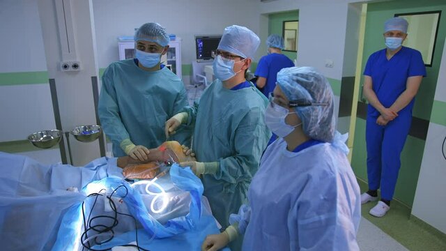 Group of surgeons in operating room with surgery equipment. Process of trauma surgery operation.