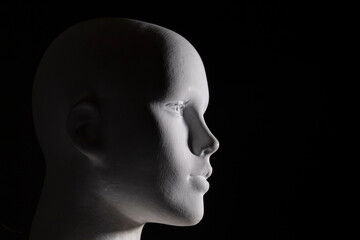 Closep to a white female manikin head portrait with black background. Photography, arts and anatomy concept