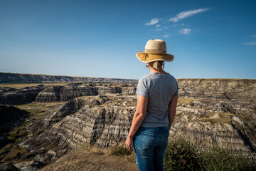 Female traveler looking at view at Horseshoe Canyon near Drumheller in Alberta, Canada.