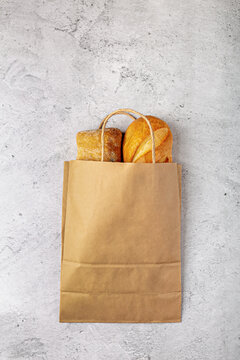 Disposable Paper Bag From A Supermarket Recyclable With Whole Baked Loaves Of Bread Flat Lay On Gray Background With Copy Space