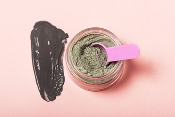 An open cosmetic jar, against the background of a smeared cream or cosmetic face mask. Purifying...