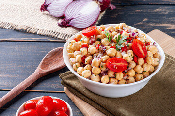 .Delicious chickpea salad with tomatoes, onions, peppers and parsley