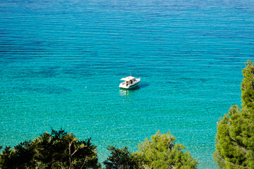 A small boat yacht on the clear tourquoise transparent sea ocean water of mediterranean balearic coast of Mallorca majorca