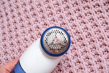 machine for removing pellets against the background of a knitted sweater.