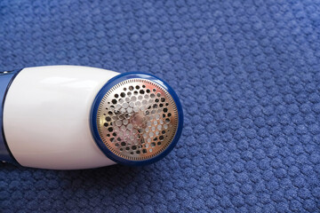 machine for removing pellets against the background of a knitted sweater.