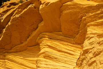 A sedimentary sandstone formation with vibrating yellow and orange colors  on a warm sunny day in the isalnd of Mallorca Spain