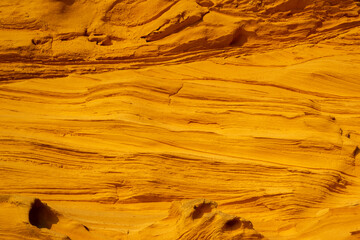 A sedimentary sandstone formation with vibrating yellow and orange colors  on a warm sunny day in the isalnd of Mallorca Spain