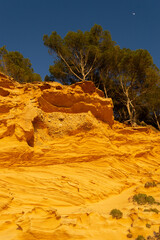 A sedimentary sandstone formation with vibrating yellow and orange colors  on a warm sunny day in the isalnd of Mallorca Spain