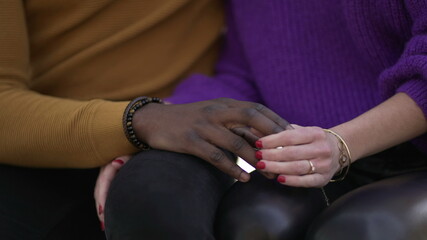 Diverse interracial young couple joining hands outside. Diversity concept union