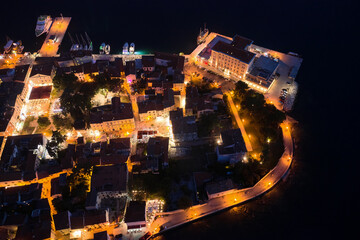 Top view of the night promenade of the old town of Porec, lit by street lights.