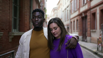 Diversity concept. Interracial couple holding hands walking outside in european street