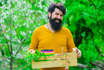 Spring farming. Farmer works in garden. Farmer with box. Bearded man preparing to planting.