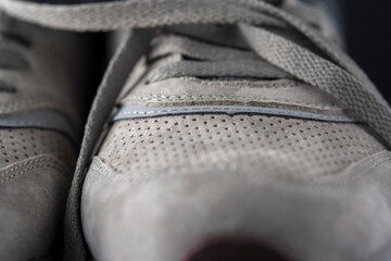 Fragment of gray men's leather sneakers, close-up.