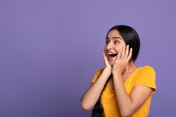 Portrait of amazed young indian woman looking at copy space