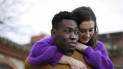 Happy millennial couple together. Black boyfriend carrying girlfriend in back