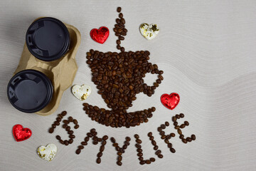 This figurine in the form of a cup of coffee with a saucer is made of coffee beans with the inscription COFFEE IS MY LIFE under it. Left two cups of coffee and decorative hearts