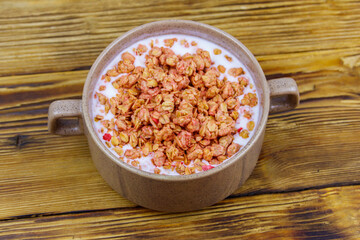 Fototapeta na wymiar Granola with milk in bowl on wooden table. Healthy breakfast concept