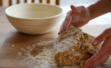 Hands of woman kneading sourdough  