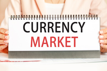 Businessman showing text CURRENCY MARKET on a cardboard