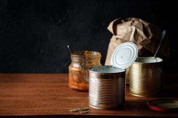 An empty tin can with nothing to eat in it, along with a fork, a knife, and an empty paper bag. I...