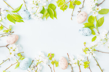 Flat lay easter composition with spring flowers and easter eggs on a light background