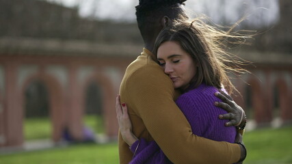 Interracial couple love and embrace. Black man hugs girlfriend, close-up hands back