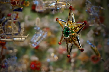 Close up photo of a small Christmas decoration in the shape of star, made of beads