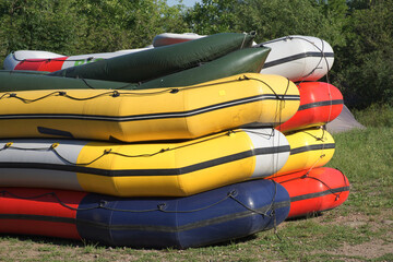 Multi-colored rafting boats stacked on top of each other.