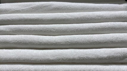 White Towels. A stack of folded cotton terry towels in close-up.