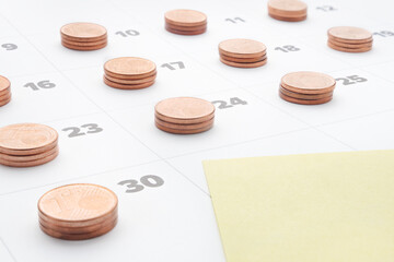 Plan save money to budget management. Cost of living. Monthly report. Empty yellow paper note in last day of month calendar with stacks euro coins. Time is money stack of coins on daily calendar pages
