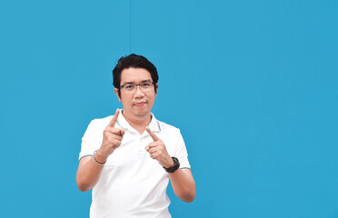 Asian man Pointing finger on wall blue color background  - 417925045