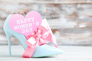 Gift box and card in shape of heart with text Happy Womens Day and blue high-heeled shoe on wooden background