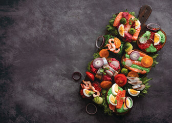 Smorrebrod, traditional Danish open sandwiches, dark rye bread with various fillings, black background, top view. copy space