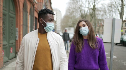 People wearing covid-19 face mask walking in street outside