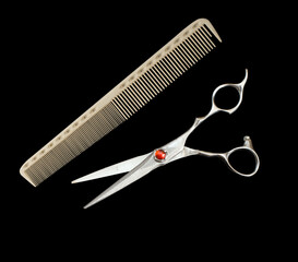 Elegant hairdressing scissors decorated with a red gemstone. Damascus scissors and comb.
