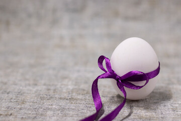 chicken egg wrapped in purple bow-knot. easter egg, present. healthy raw food
