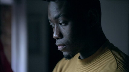 Worried black African man standing indoors at home