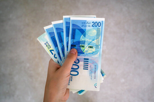 Hand holding many 200 israel shekel banknotes. Save Israel! Support Israel!
