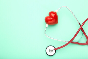 Stethoscope with red heart on mint background