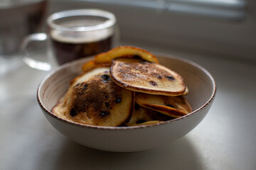 pancakes with berries in a plate. Coffee in a transparent cup. Breakfast